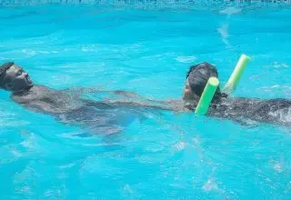 A swimmer practising with a pool noodle